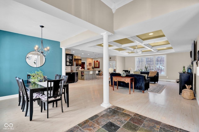 dining area featuring ornate columns, a chandelier, beam ceiling, and coffered ceiling