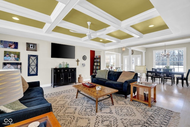 living room featuring ornate columns, ceiling fan with notable chandelier, coffered ceiling, and beamed ceiling