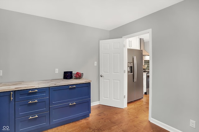 interior space featuring stainless steel refrigerator with ice dispenser and hardwood / wood-style flooring