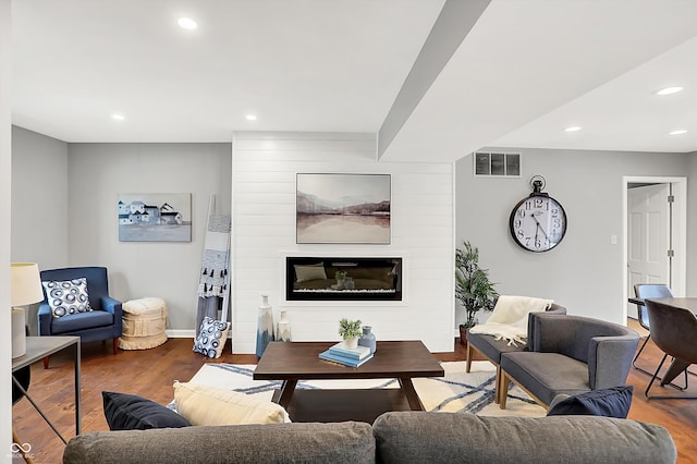 living room with a fireplace and wood-type flooring