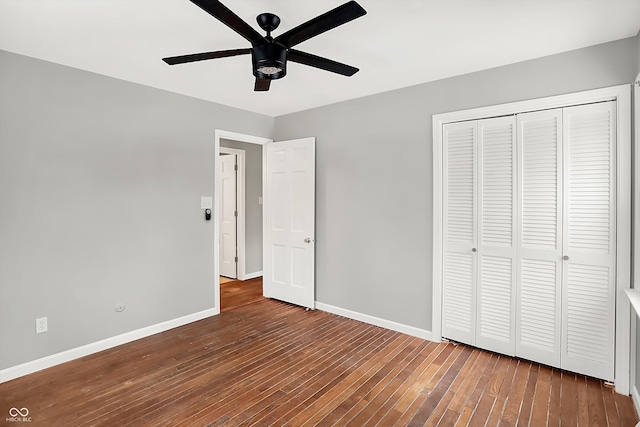 unfurnished bedroom with ceiling fan, a closet, and dark wood-type flooring