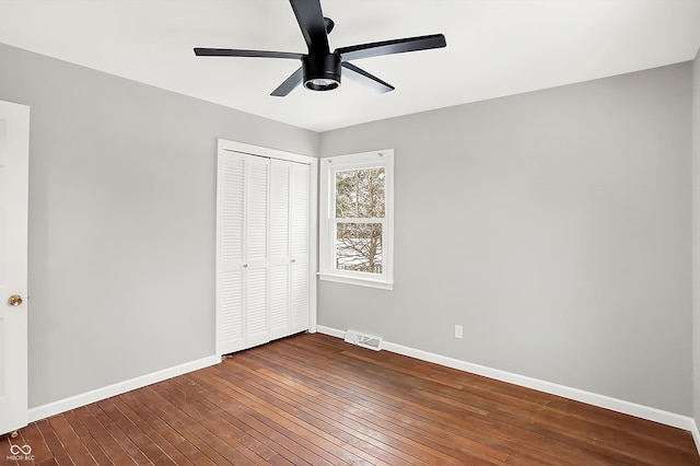 unfurnished bedroom with ceiling fan, a closet, and hardwood / wood-style flooring