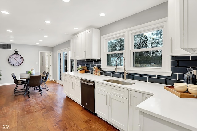 kitchen featuring decorative backsplash, dark wood-type flooring, dishwasher, white cabinets, and sink