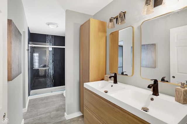 bathroom featuring a shower with door and vanity