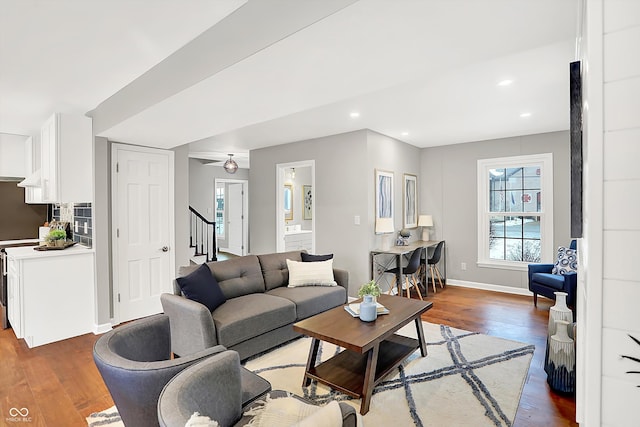 living room featuring ceiling fan and dark hardwood / wood-style flooring