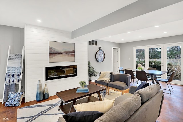 living room with french doors, a large fireplace, and hardwood / wood-style floors