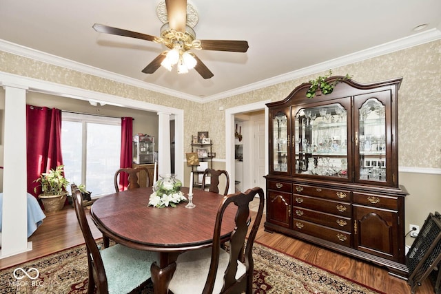 dining space with ornate columns, ornamental molding, and hardwood / wood-style flooring