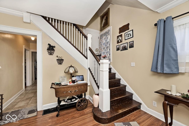 stairs with hardwood / wood-style flooring and crown molding