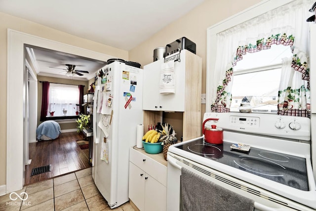 kitchen with white appliances, white cabinetry, ornamental molding, light tile patterned flooring, and ceiling fan