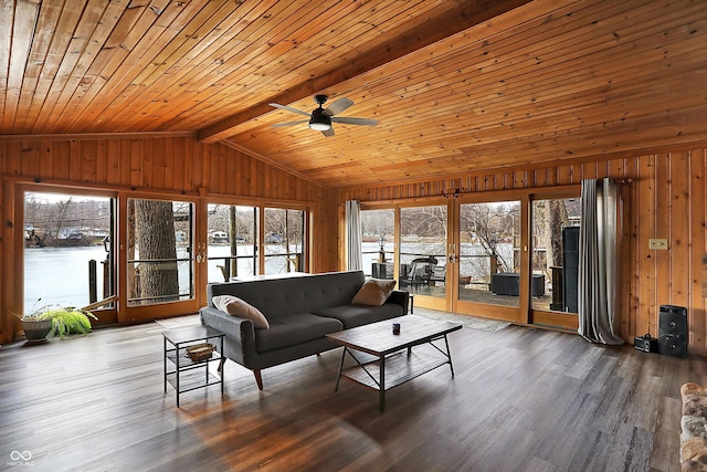 living room with a wealth of natural light, wooden walls, and lofted ceiling with beams