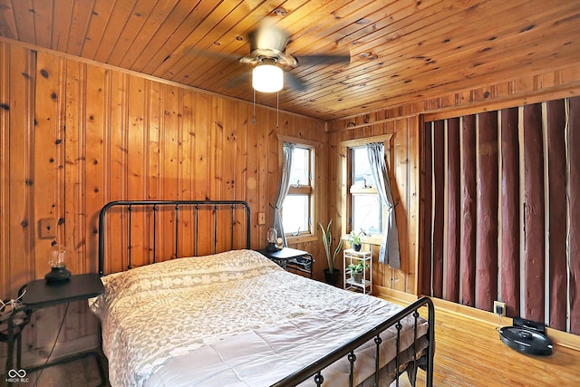 bedroom with wooden ceiling and wood walls