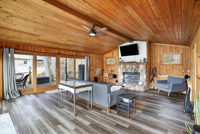 living room with wood ceiling, vaulted ceiling with beams, hardwood / wood-style floors, a fireplace, and wood walls