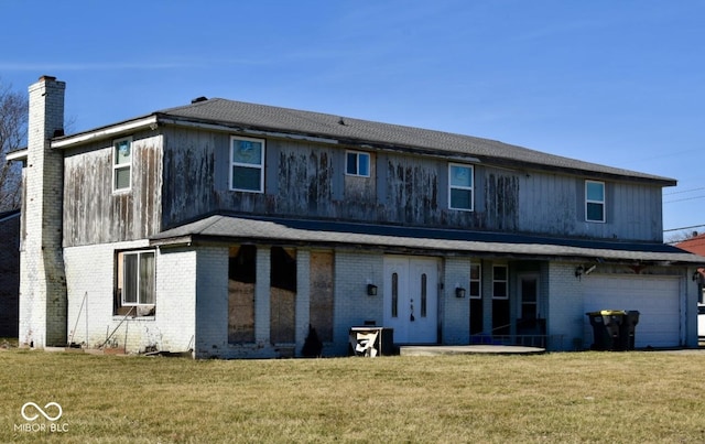 back of property featuring a garage and a yard