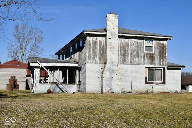 rear view of house featuring a lawn