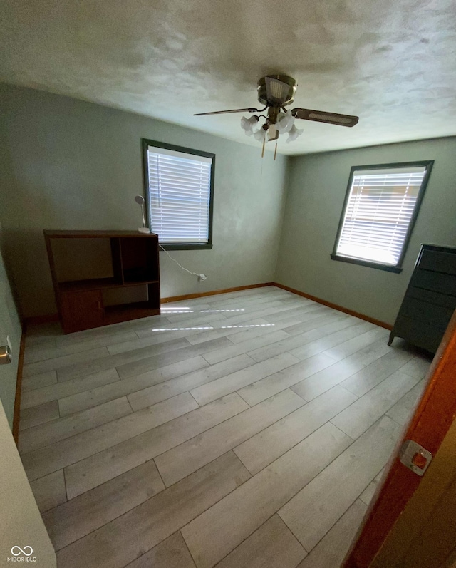 spare room with ceiling fan, a textured ceiling, and light hardwood / wood-style flooring