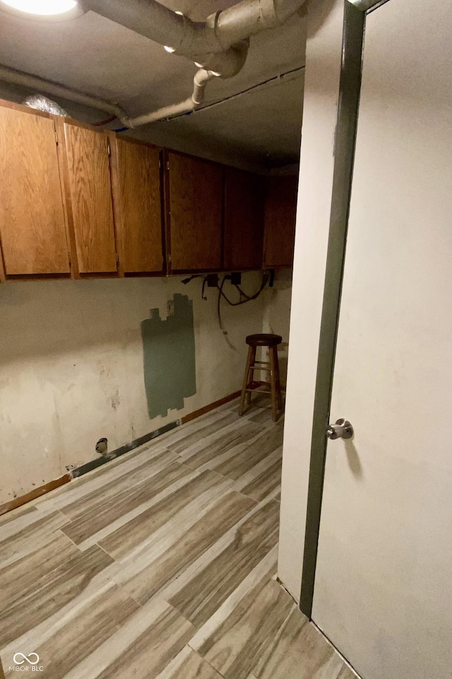 basement with light hardwood / wood-style flooring