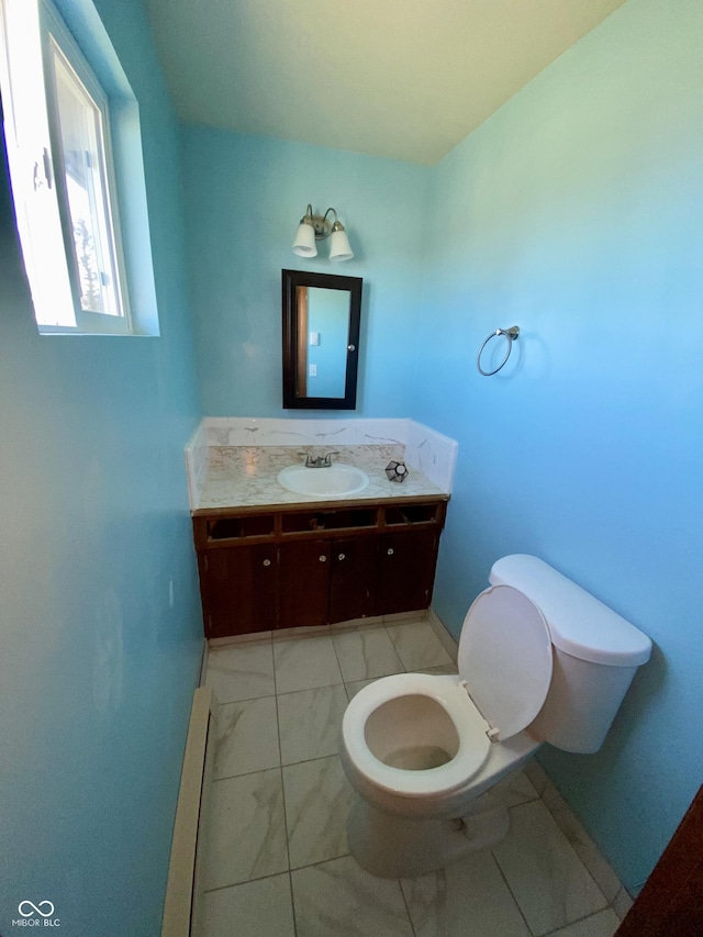 bathroom with toilet, vanity, tile patterned floors, and a baseboard radiator