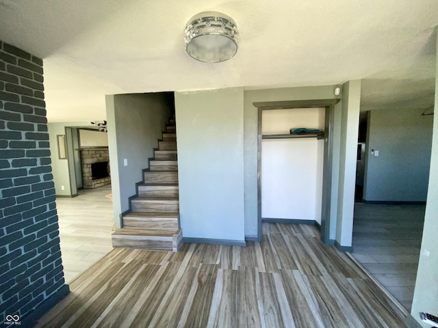 stairs featuring wood-type flooring and a fireplace