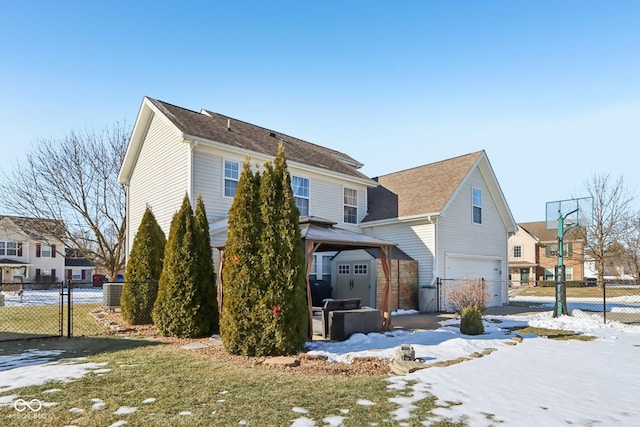 exterior space with a garage, a gazebo, and a lawn