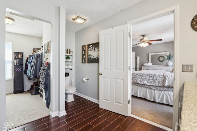 bathroom with ceiling fan, a textured ceiling, and toilet