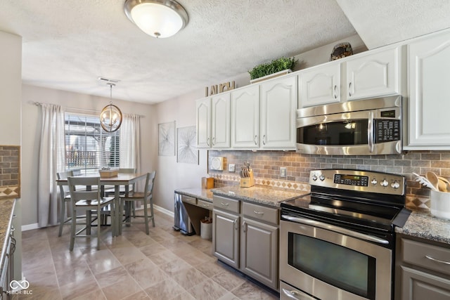 kitchen with light stone countertops, appliances with stainless steel finishes, and white cabinets