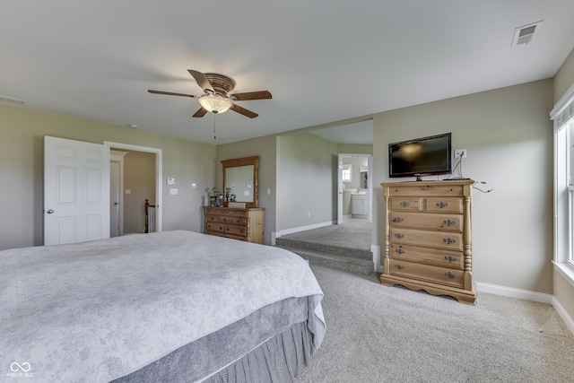 carpeted bedroom featuring ceiling fan and ensuite bath