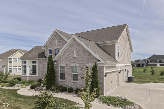 view of front of property featuring a front yard, a garage, and cooling unit