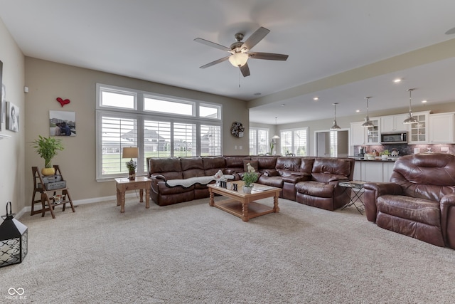 carpeted living room with ceiling fan