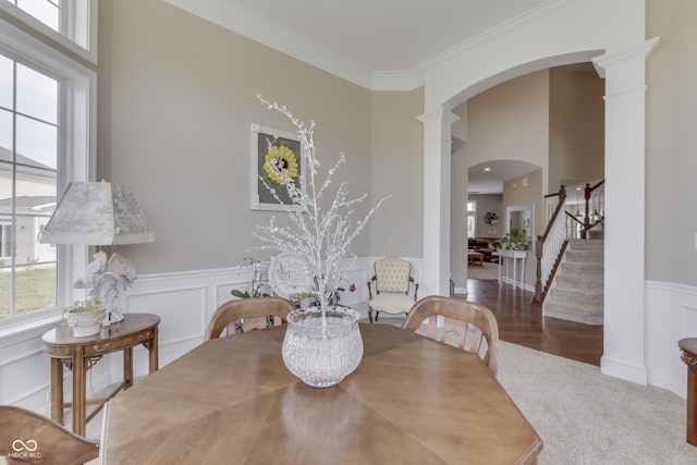 dining space featuring carpet floors, ornamental molding, and decorative columns