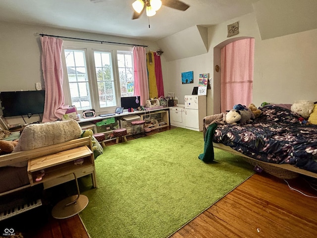 bedroom with ceiling fan, hardwood / wood-style floors, and vaulted ceiling