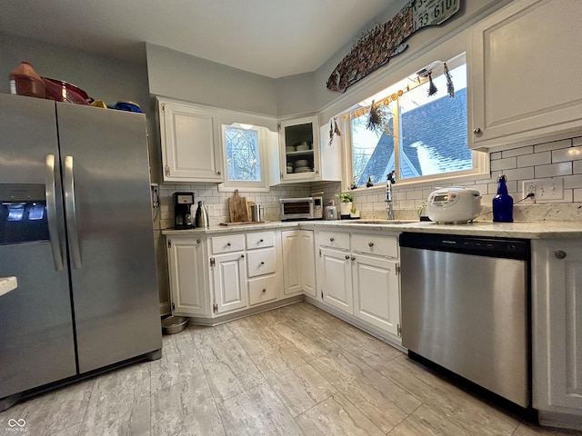 kitchen featuring sink, white cabinetry, appliances with stainless steel finishes, and tasteful backsplash