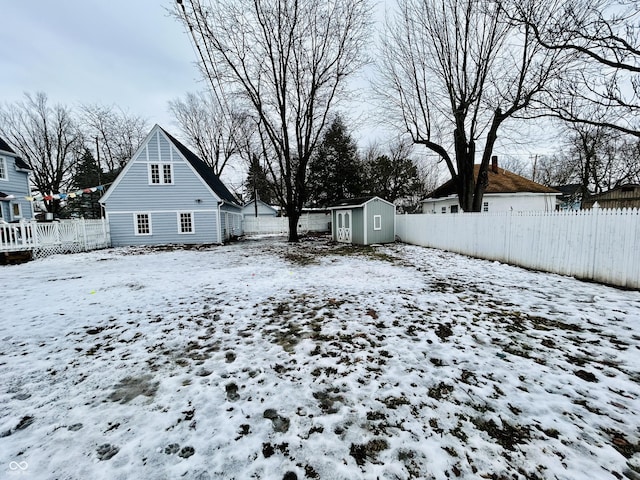 yard covered in snow featuring a storage shed