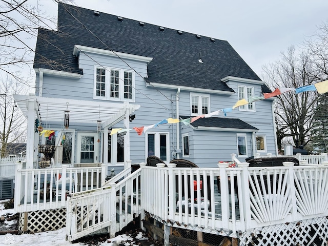 snow covered house with a deck and a pergola