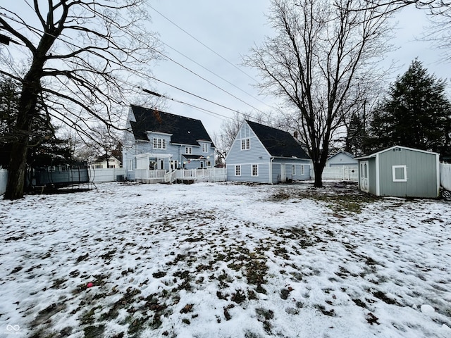 yard layered in snow featuring a shed