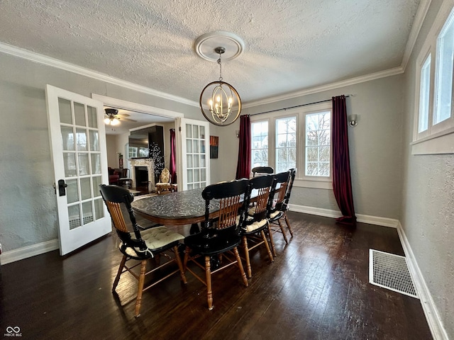 dining space featuring ceiling fan with notable chandelier, a textured ceiling, dark hardwood / wood-style flooring, and crown molding