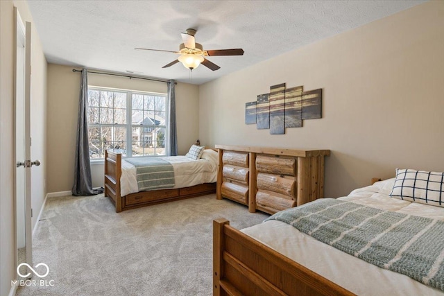 carpeted bedroom with a textured ceiling and ceiling fan