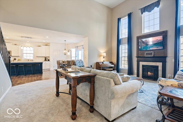 living room featuring a large fireplace, a chandelier, and light wood-type flooring