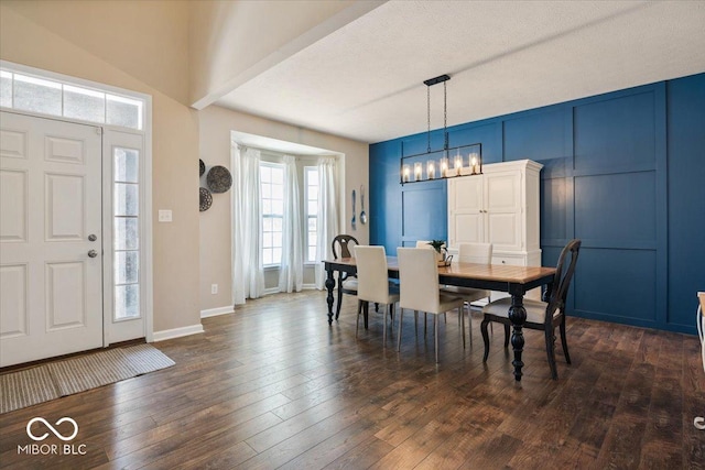 dining room with an inviting chandelier, dark hardwood / wood-style floors, and a textured ceiling