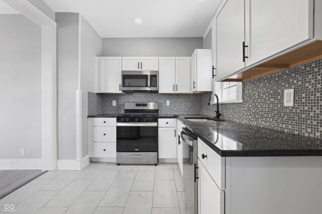 kitchen with sink, white cabinets, appliances with stainless steel finishes, and tasteful backsplash