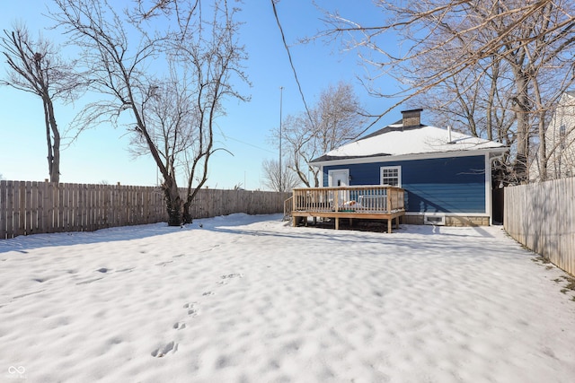 yard covered in snow with a deck