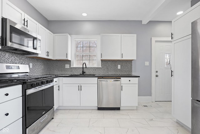 kitchen with backsplash, sink, white cabinets, and appliances with stainless steel finishes