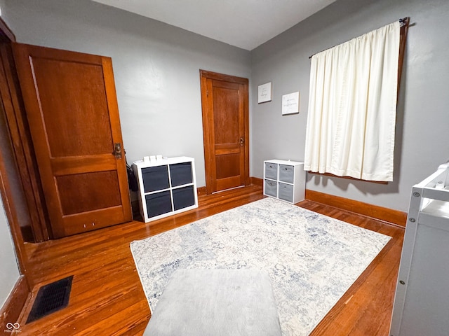 bedroom with dark hardwood / wood-style flooring