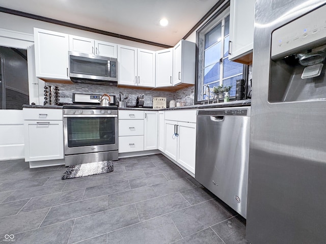 kitchen with tasteful backsplash, white cabinets, stainless steel appliances, and ornamental molding