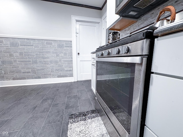 room details with stainless steel range, white cabinets, white refrigerator, and crown molding