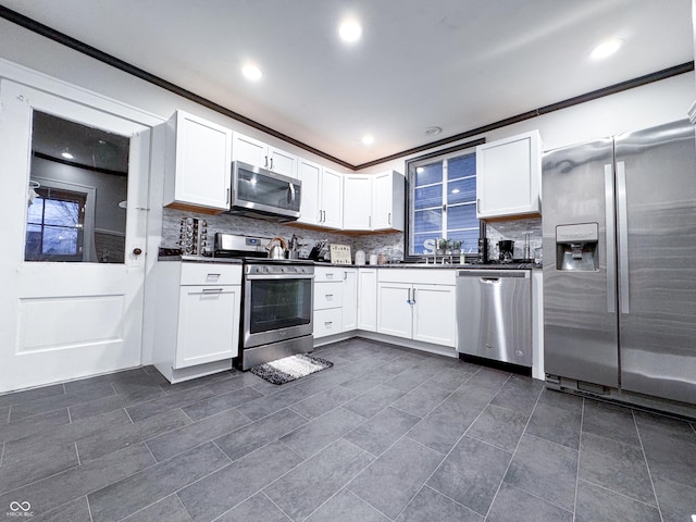 kitchen featuring sink, white cabinetry, crown molding, and stainless steel appliances