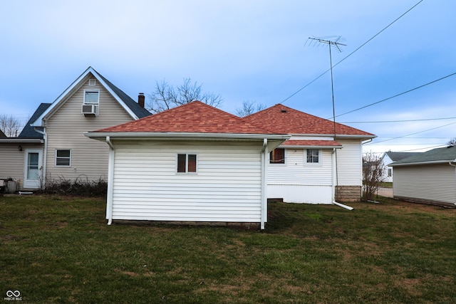 back of property with cooling unit and a yard