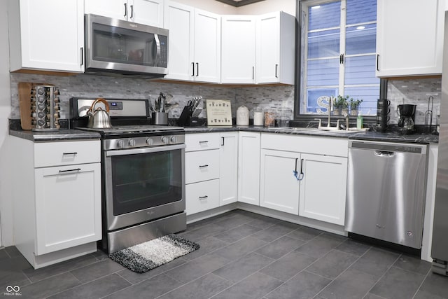 kitchen with stainless steel appliances, backsplash, white cabinets, and sink