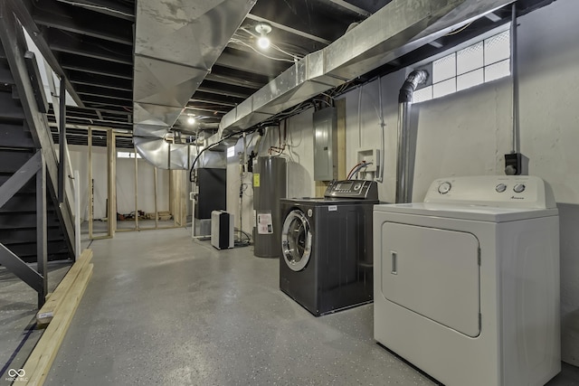 basement featuring electric water heater, washer and clothes dryer, heating unit, and electric panel