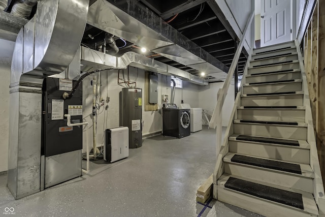 basement with electric panel, heating unit, independent washer and dryer, and electric water heater