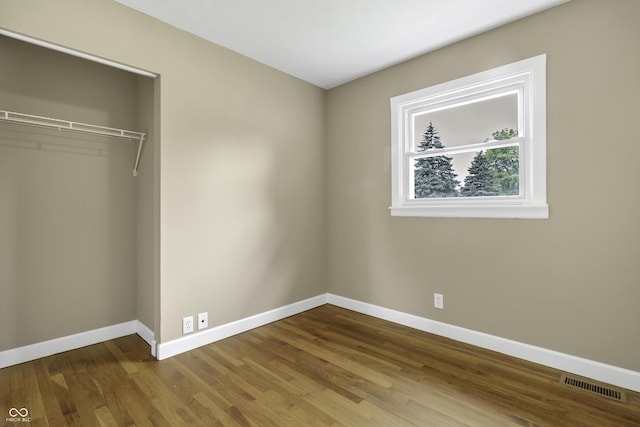 unfurnished bedroom with hardwood / wood-style floors and a closet